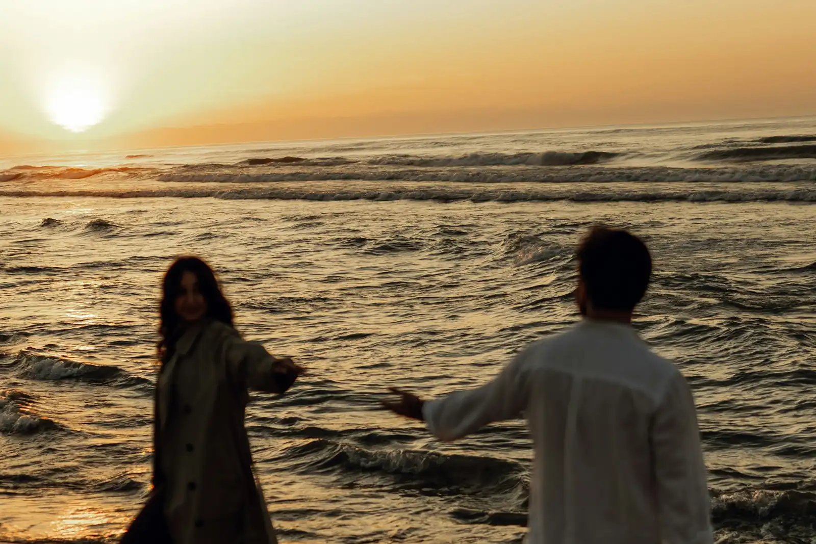 Couple on an empty shore at sunset