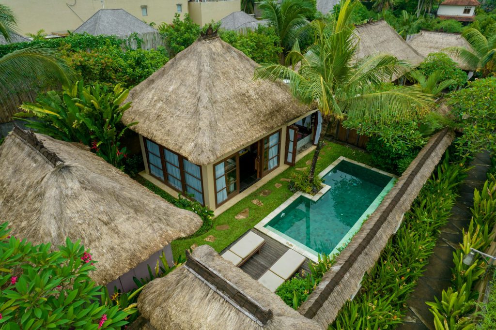 Villa and pool seen from above, set into dense green