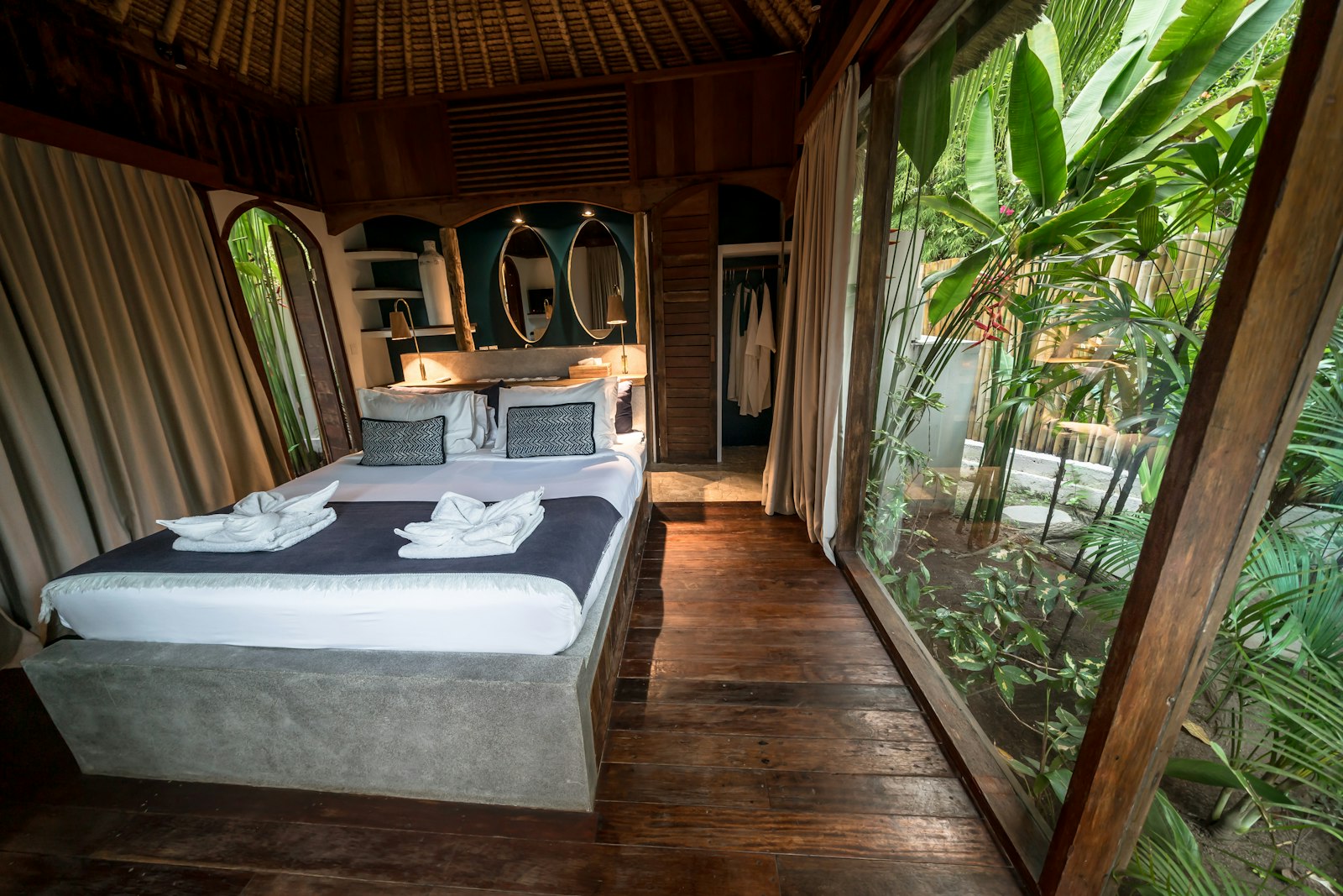 Cozy bedroom with large window overlooking lush greenery