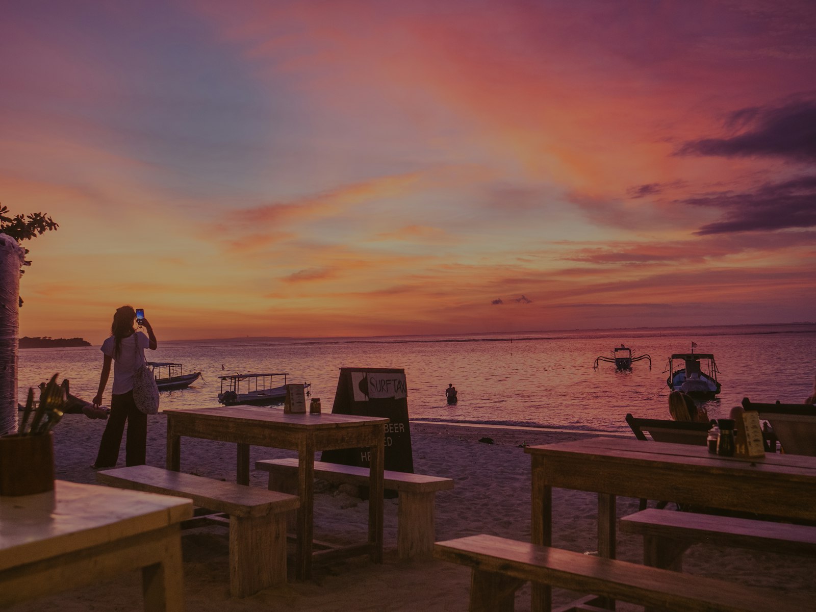 Sunset over a tropical beach with boats